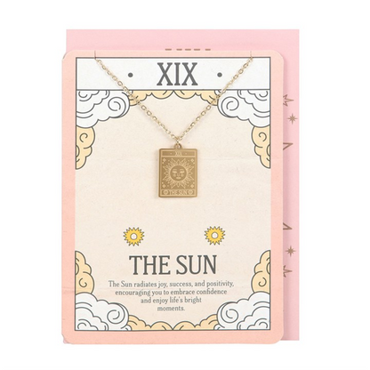 Gold necklace with a pendant on a decorative card with 'XIX The Sun' text.