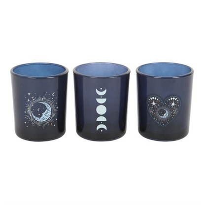 Three dark blue ceramic tumblers with celestial designs on a white background