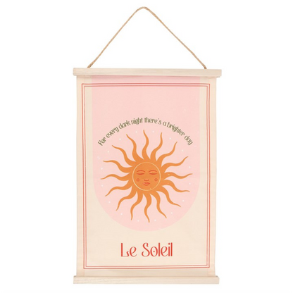 Decorative wall hanging with sun illustration and text on a pink background