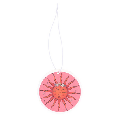 Decorative sun-shaped pink ornament with a face on a white background