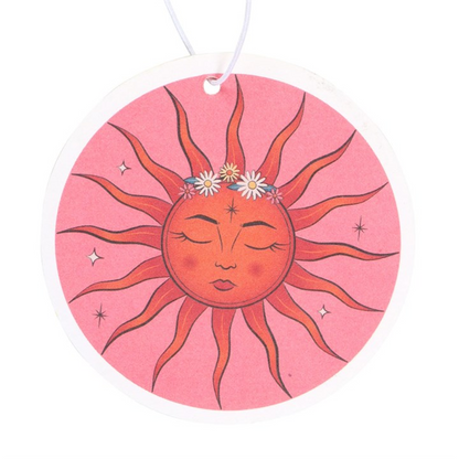 Decorative sun design on a pink background with a white string, resembling an air freshener.