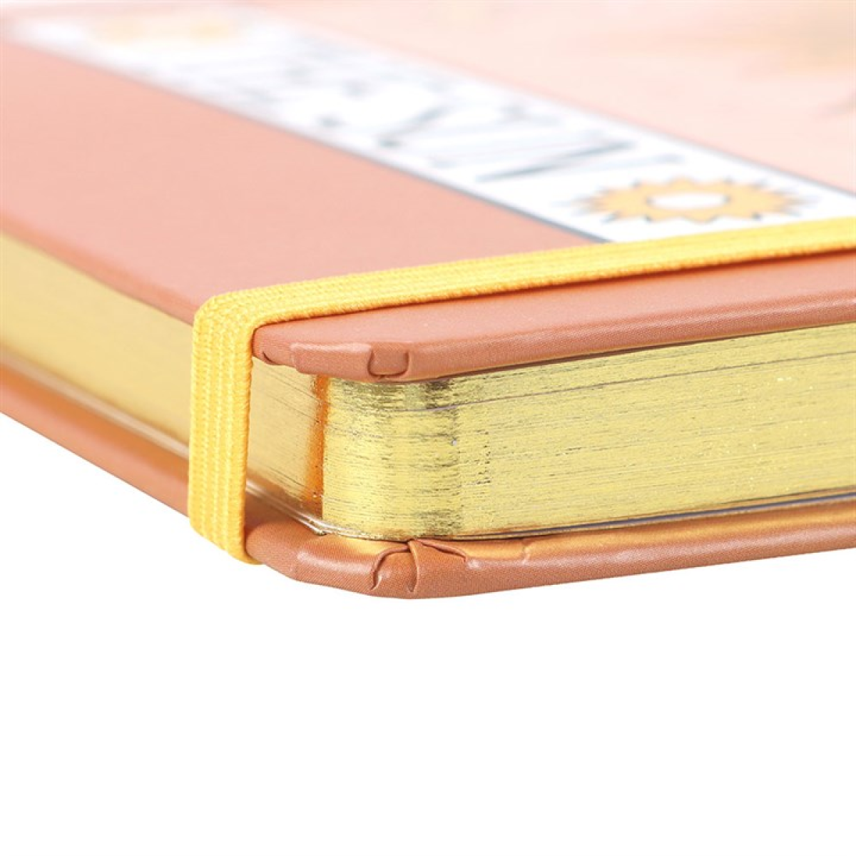 Close-up of a notebook with gold edging with a yellow and brown design.