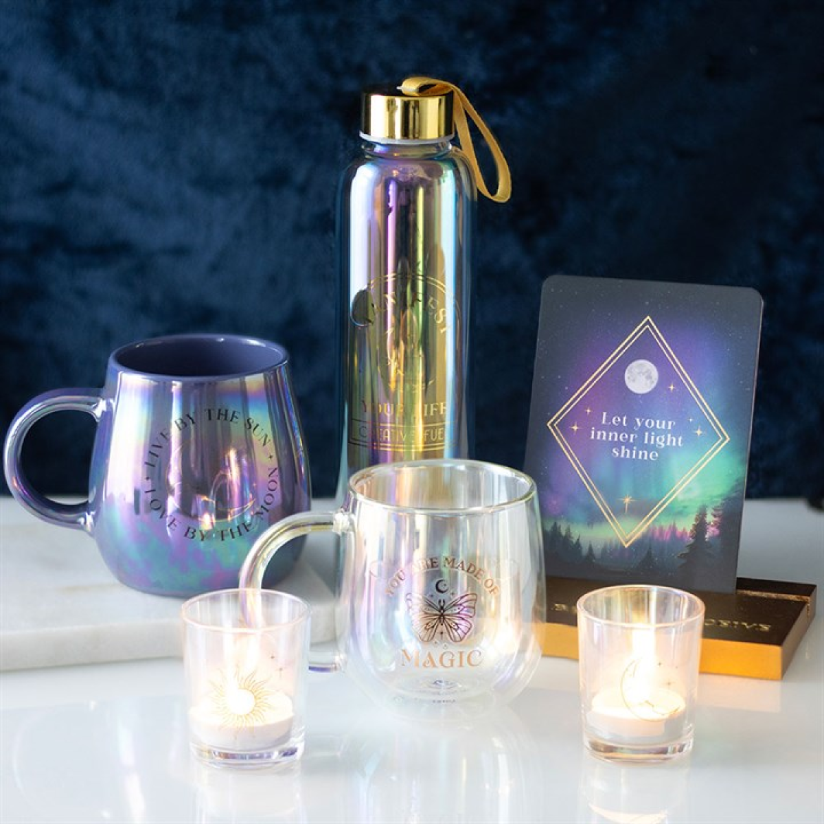 Decorative items including a mug, water bottle, cards, and candles on a dark background