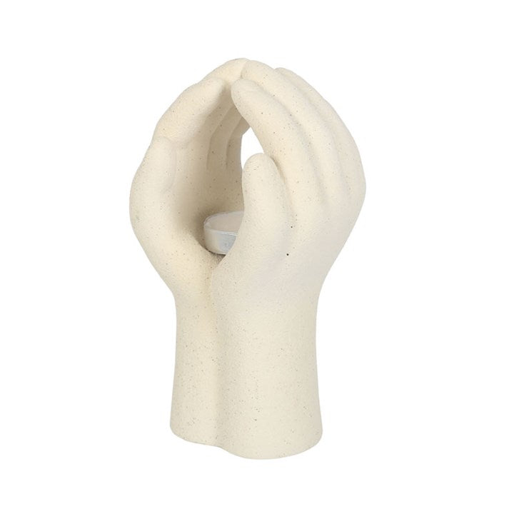 White ceramic sculpture of intertwined hands on a white background