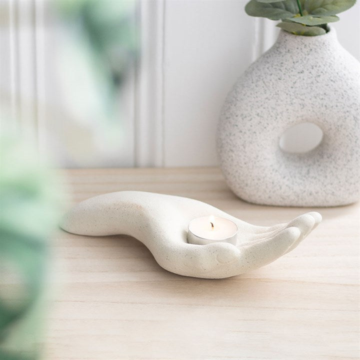 white candle holder in the shape of an open palm