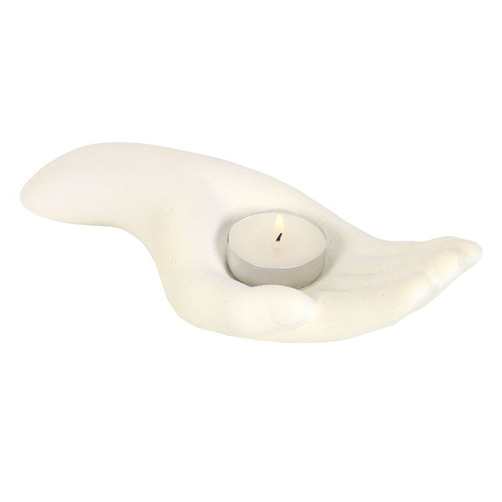 white candle holder in the shape of an open palm