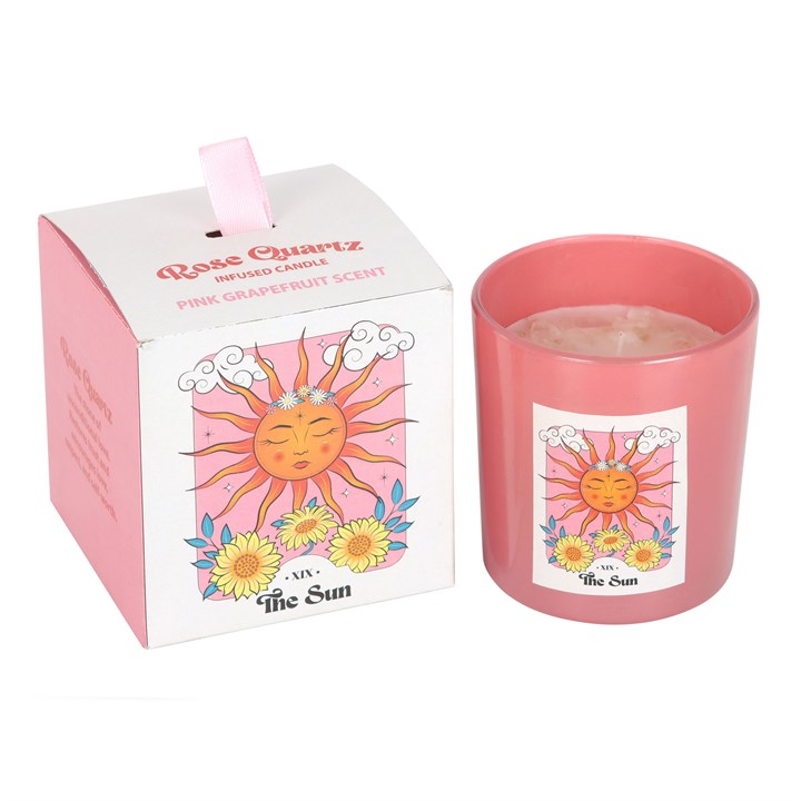 Pink candle with sun design and matching box on a white background