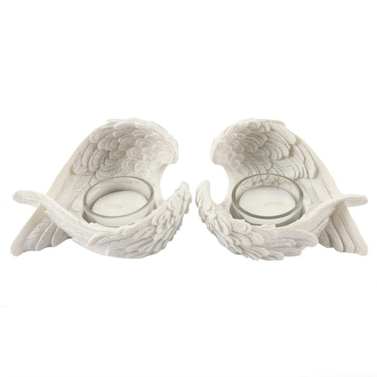 Two white ceramic angel wing candle holders on a white background