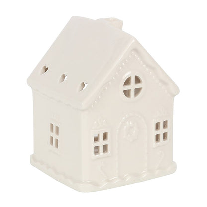 White cermaic candle holder in the shape of a house