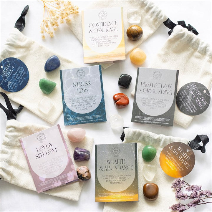 Collection of wellness items including cards, stones, and pouches on a white surface.