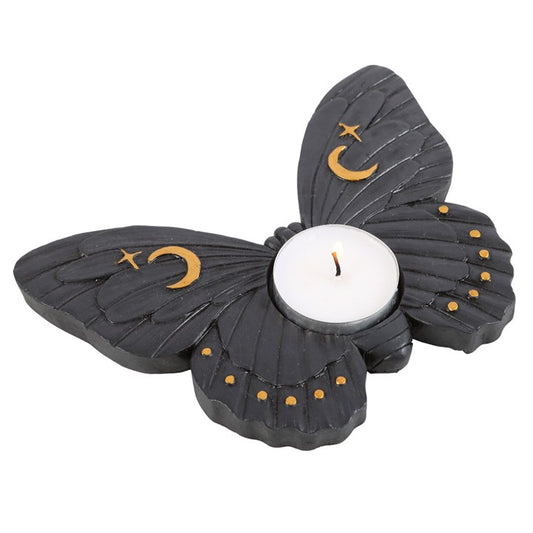 Butterfly-shaped candle holder with a candle inside on a white background