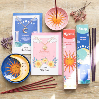 Incense sticks and packaging with sun and moon designs on a wooden surface.