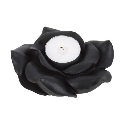 Black flower-shaped candle holder with a white candle inside on a white background