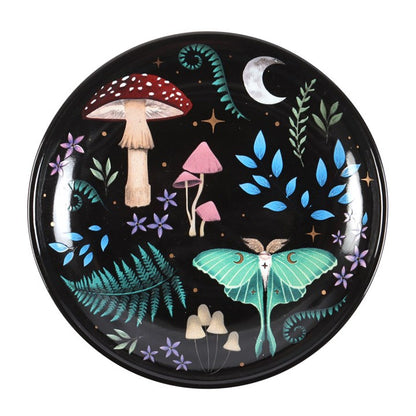 Decorative plate with mushrooms, leaves, and a butterfly on a black background