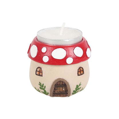 Fairy house-shaped candle with red polka dot roof on a white background