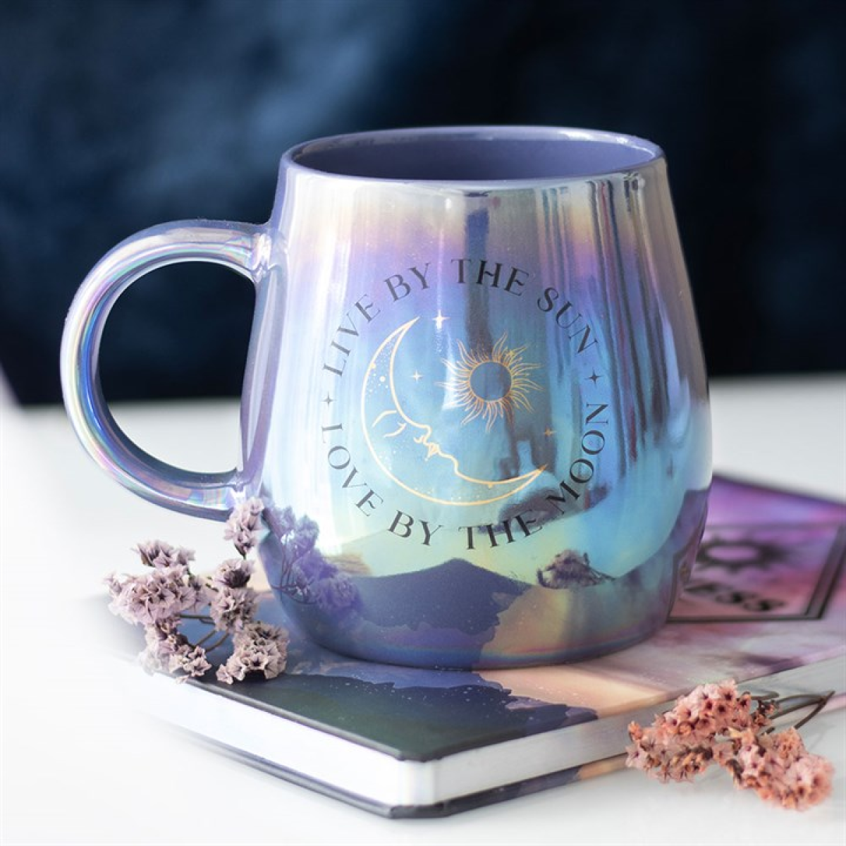 Iridescent mug with celestial design and text on a blurred background