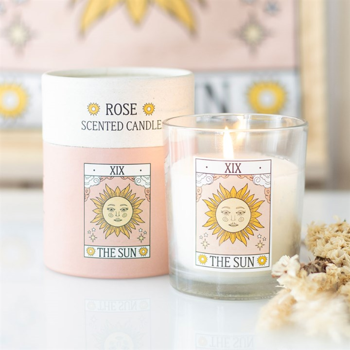 Rose scented candle labeled 'The Sun' with a blurred decorative background