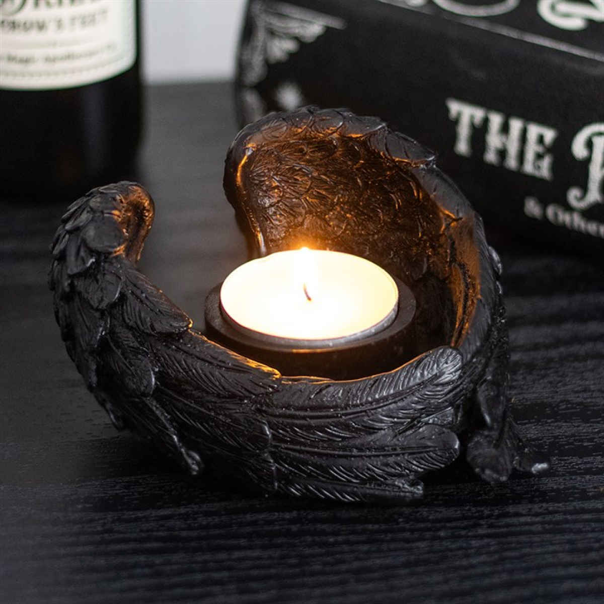 Decorative candle holder with a lit candle on a dark surface